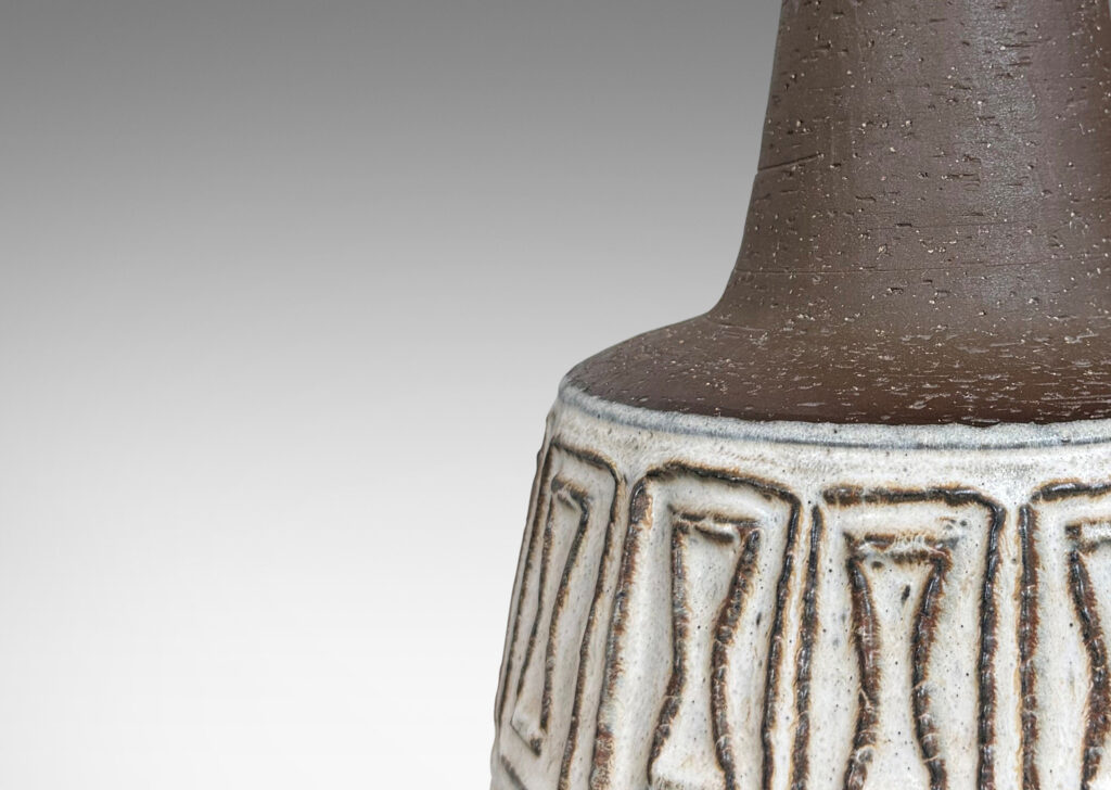 Gallery BAC drum forms with relief hourglass motifs and conical necks, glazed in matte brown