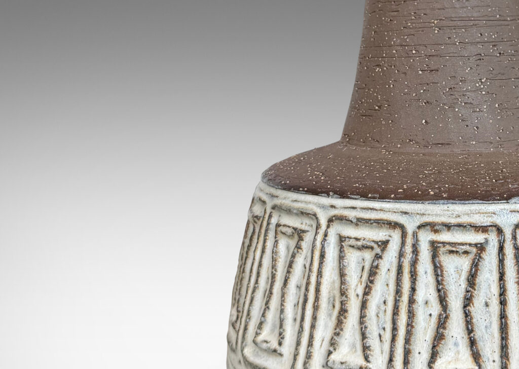 Gallery BAC drum forms with relief hourglass motifs and conical necks, glazed in matte brown