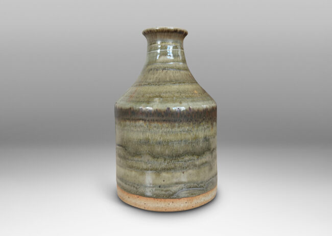 Gallery BAC cylindrical bottle-like form with sprouting mouth, glazed in a striae-effect flowing greenish-gray