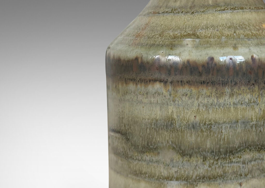 Gallery BAC cylindrical bottle-like form with sprouting mouth, glazed in a striae-effect flowing greenish-gray