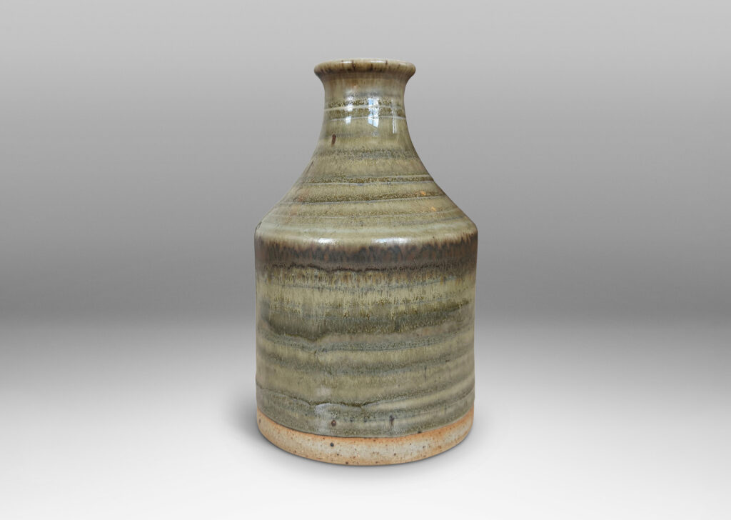 Gallery BAC cylindrical bottle-like form with sprouting mouth, glazed in a striae-effect flowing greenish-gray