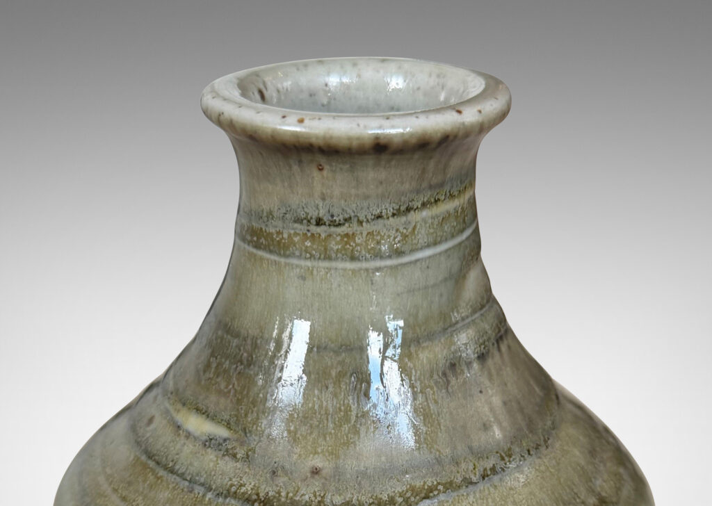 Gallery BAC cylindrical bottle-like form with sprouting mouth, glazed in a striae-effect flowing greenish-gray