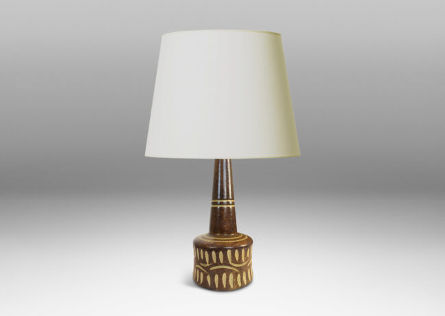 Gallery BAC drum form and conical neck, glazed in dappled brown, with carved details in ivory