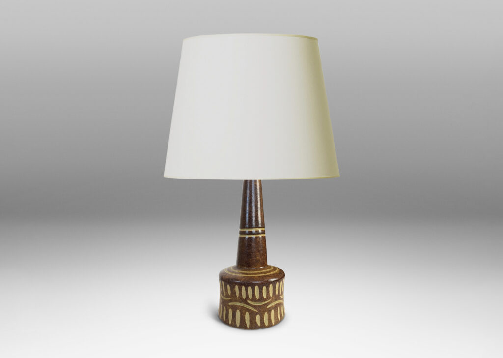 Gallery BAC drum form and conical neck, glazed in dappled brown, with carved details in ivory