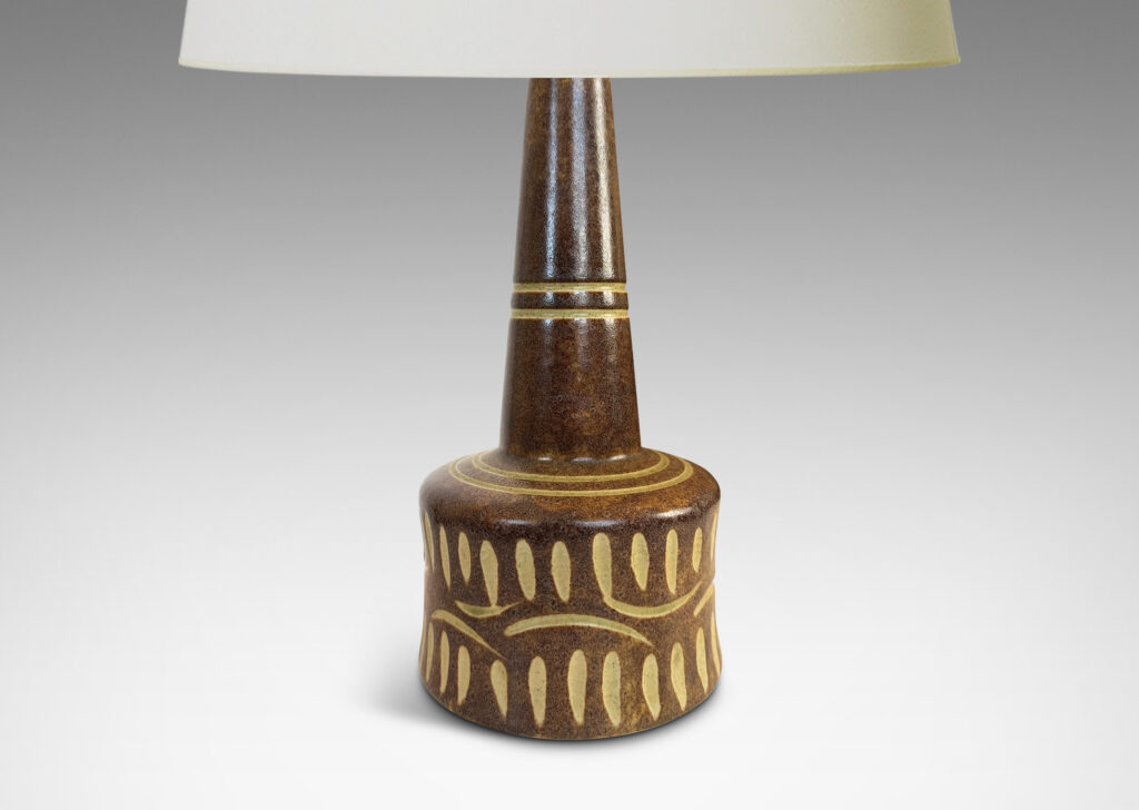 Gallery BAC drum form and conical neck, glazed in dappled brown, with carved details in ivory