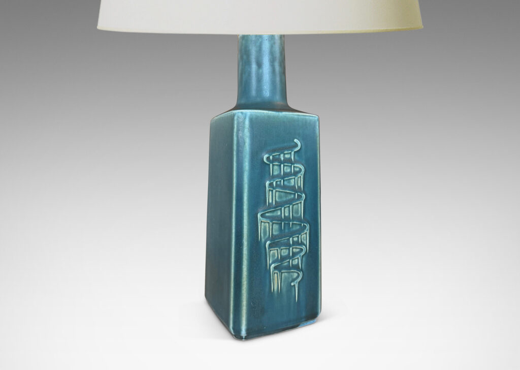 Gallery BAC square pillar forms with chamfered corners and serpentine pattern reliefs, glazed in a matte subdued turquoise