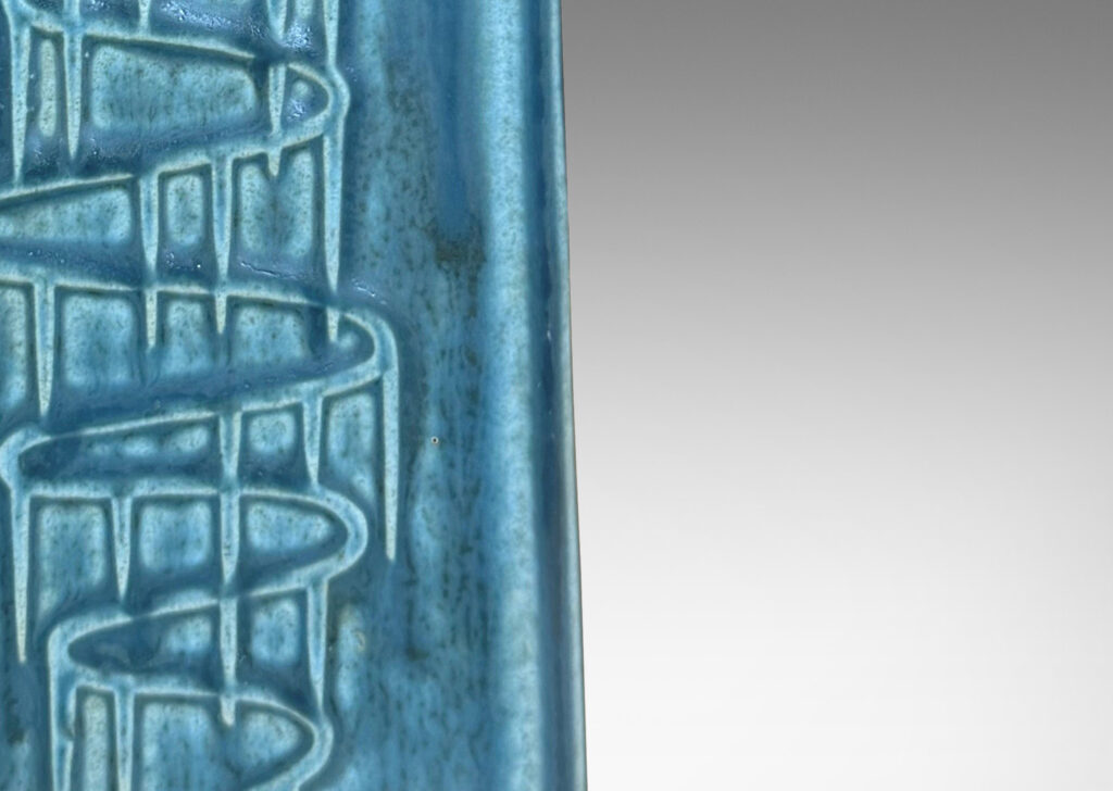 Gallery BAC square pillar forms with chamfered corners and serpentine pattern reliefs, glazed in a matte subdued turquoise