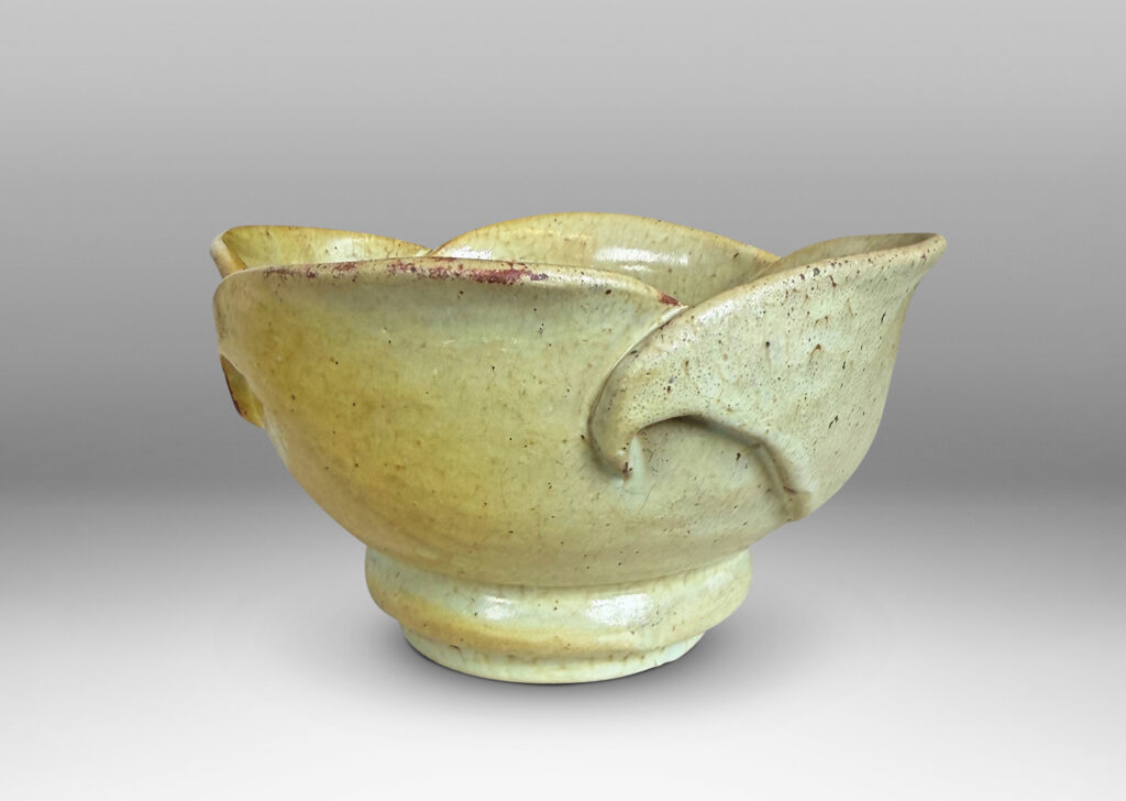 Gallery BAC footed abstracted floral design with overlapping petal forms, glazed in a flowing pale yellow