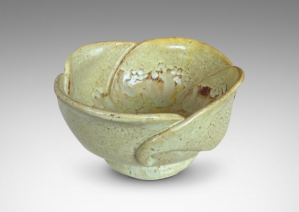 Gallery BAC footed abstracted floral design with overlapping petal forms, glazed in a flowing pale yellow