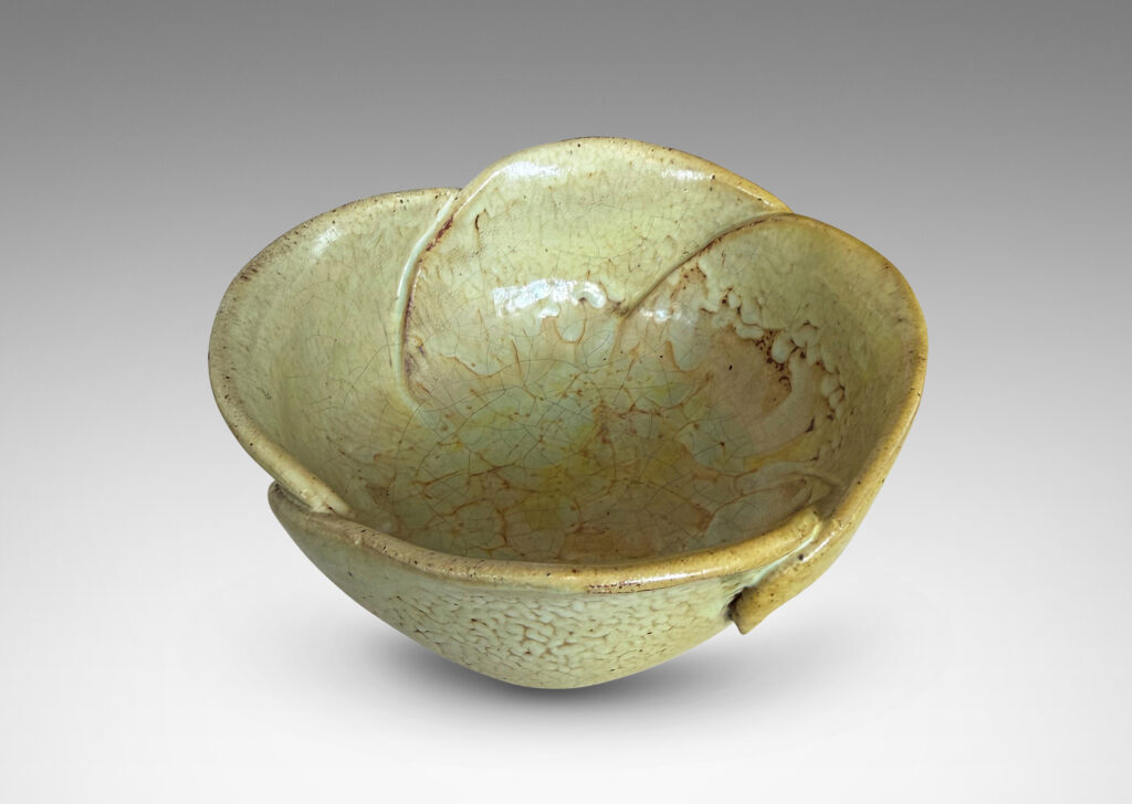 Gallery BAC footed abstracted floral design with overlapping petal forms, glazed in a flowing pale yellow