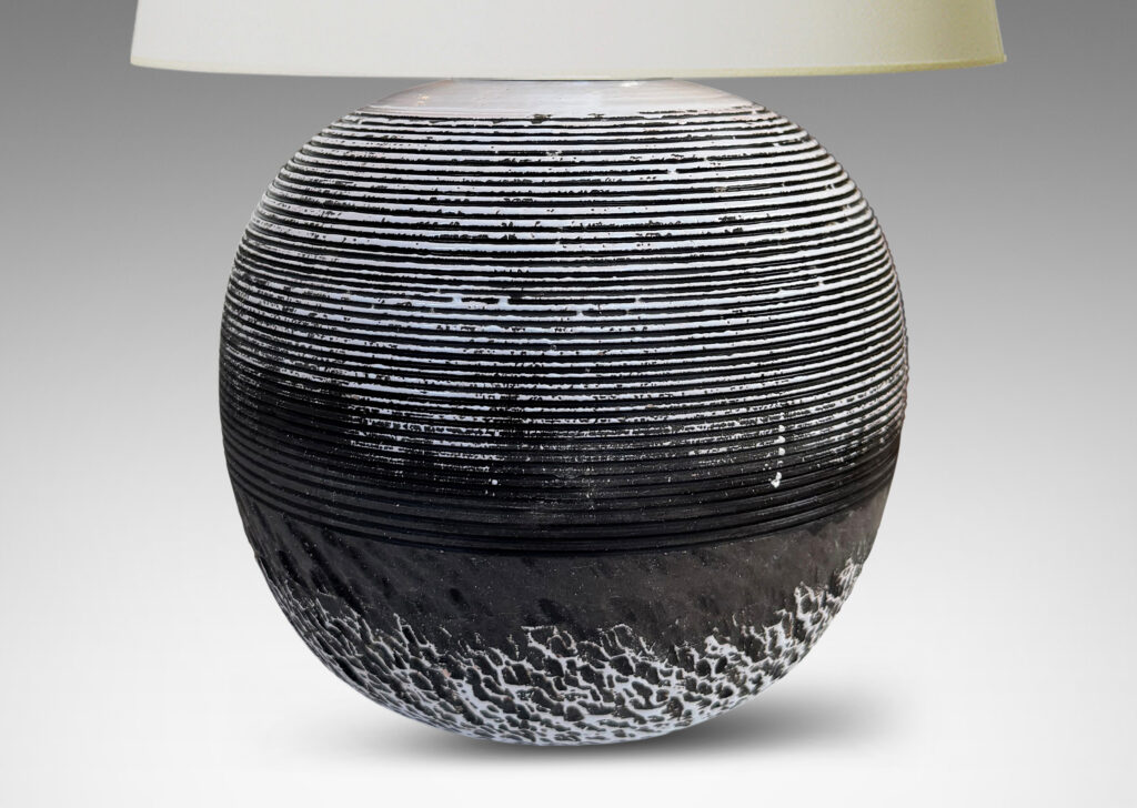 Gallery BAC globe form with carved horizontal ribbing on top and rustic texture on the bottom, glazed in matte brown and shiny white