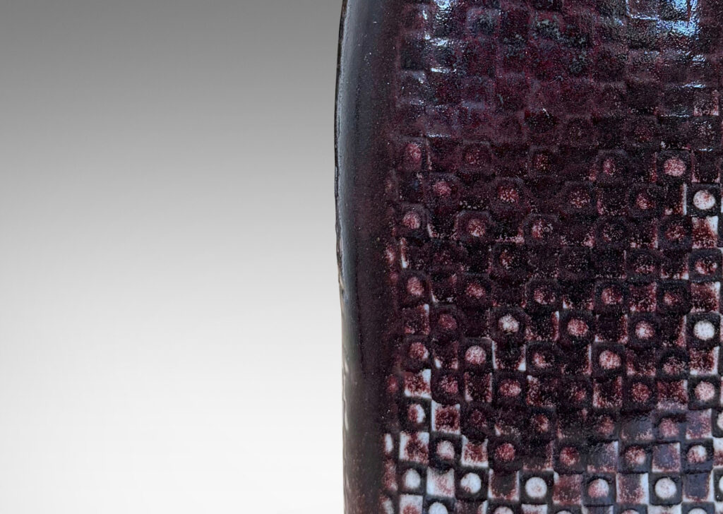 Gallery BAC tall squared bottle-like form with impressed checker circle-square pattern, glazed in flowing oxblood burgundy