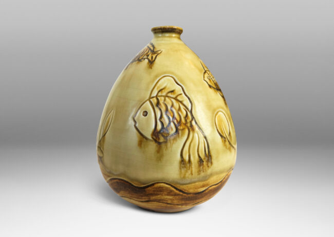 Gallery BAC drop form with carved reliefs of goldfish and water flora, glazed in a thin amber-tan with brown accents