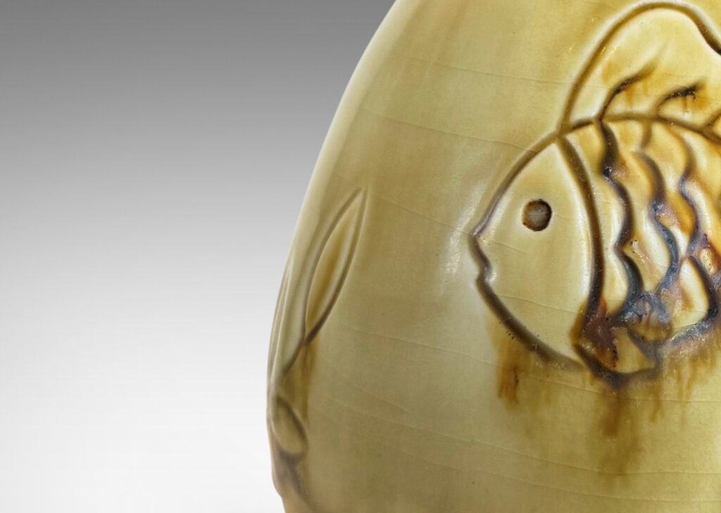 Gallery BAC drop form with carved reliefs of goldfish and water flora, glazed in a thin amber-tan with brown accents