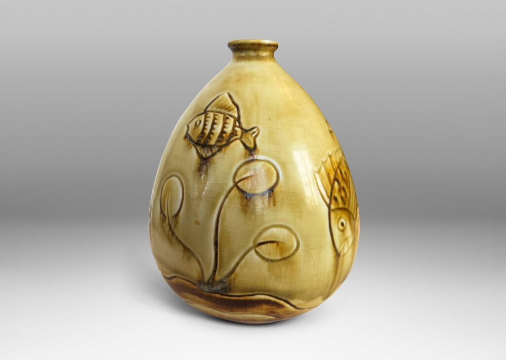 Gallery BAC drop form with carved reliefs of goldfish and water flora, glazed in a thin amber-tan with brown accents