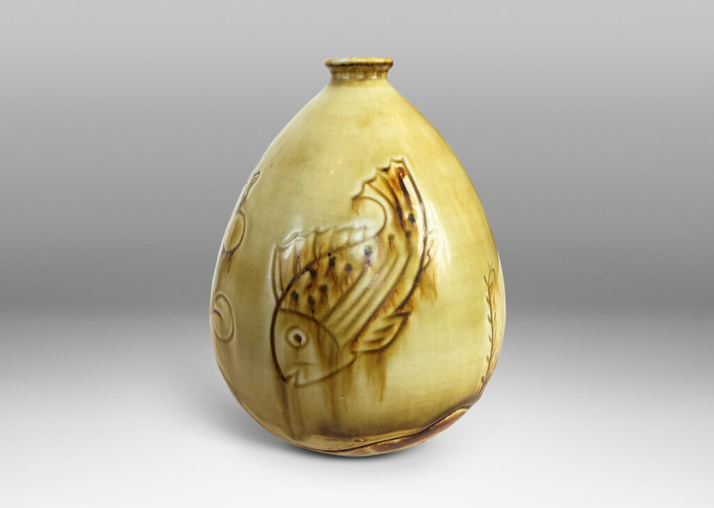Gallery BAC drop form with carved reliefs of goldfish and water flora, glazed in a thin amber-tan with brown accents