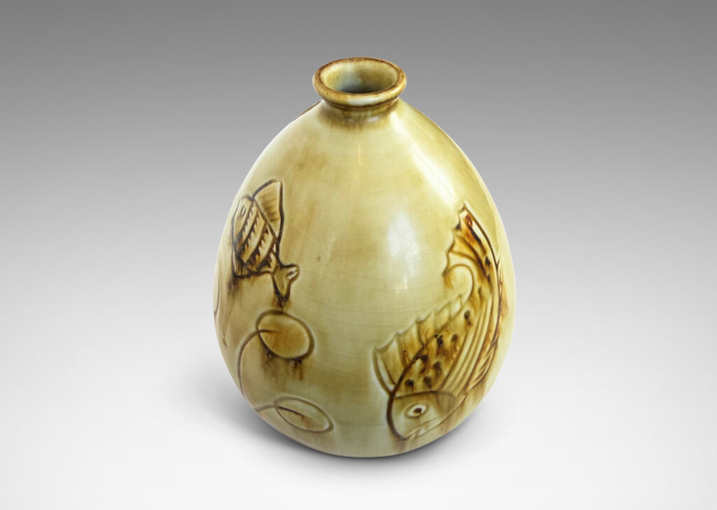 Gallery BAC drop form with carved reliefs of goldfish and water flora, glazed in a thin amber-tan with brown accents