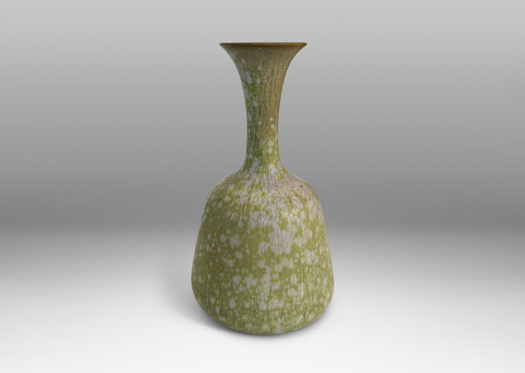 Gallery BAC angled form with delicate trumpeting neck and mouth, glazed in a dappled pale green