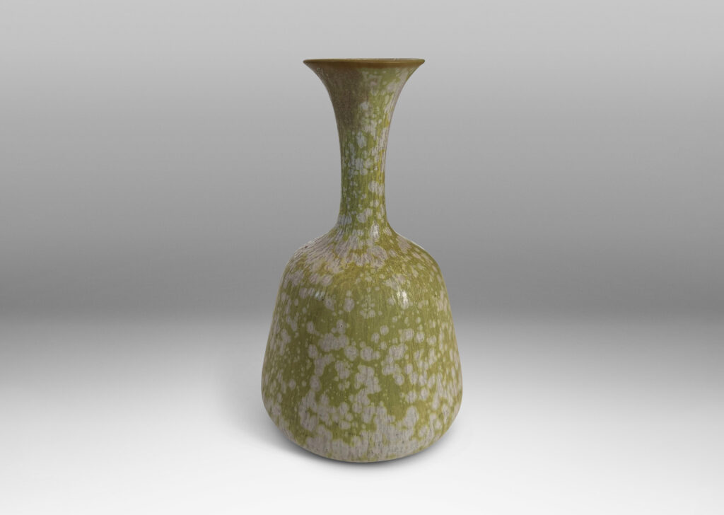Gallery BAC angled form with delicate trumpeting neck and mouth, glazed in a dappled pale green