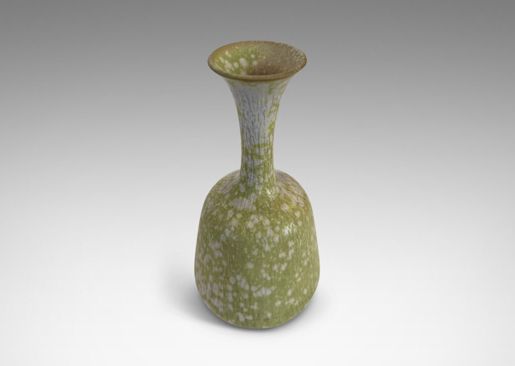 Gallery BAC angled form with delicate trumpeting neck and mouth, glazed in a dappled pale green