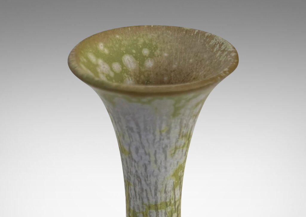 Gallery BAC angled form with delicate trumpeting neck and mouth, glazed in a dappled pale green