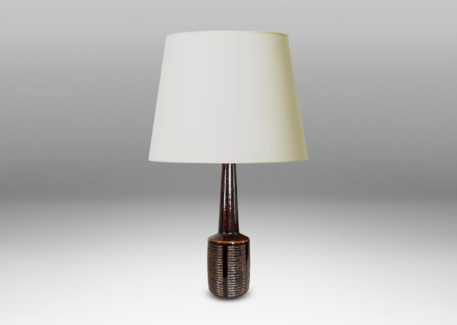 Gallery BAC cylindrical form ornamented with columns of carved lines and a tall conical neck, glazed in a shiny brown glaze