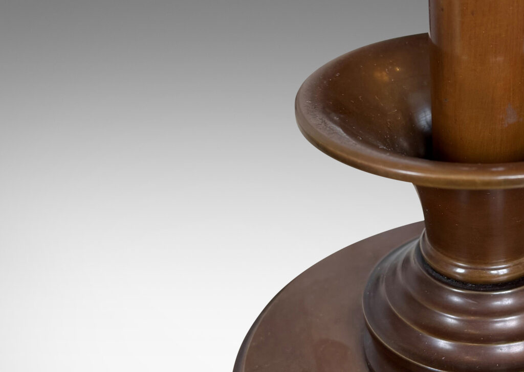 Gallery BAC disk plinth and muscular stand, with trumpeting fob on a ridged base, featuring a fine, warm brown