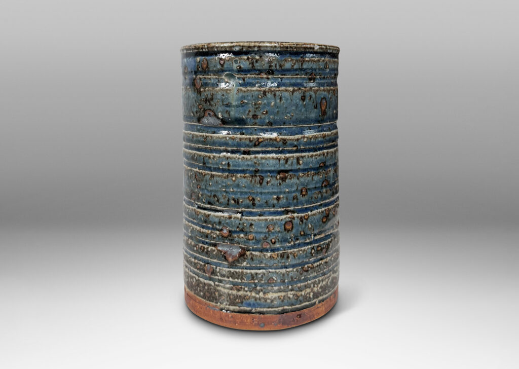 Gallery BAC cylindrical form with grog texture and carved ridging, glazed in a shiny cornflower blue with lustrous brown