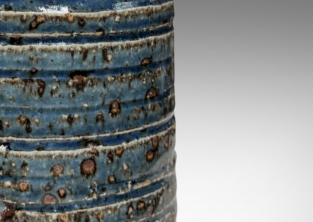 Gallery BAC cylindrical form with grog texture and carved ridging, glazed in a shiny cornflower blue with lustrous brown