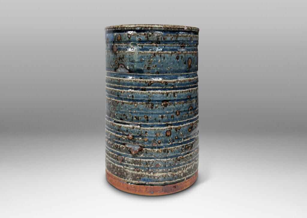 Gallery BAC cylindrical form with grog texture and carved ridging, glazed in a shiny cornflower blue with lustrous brown