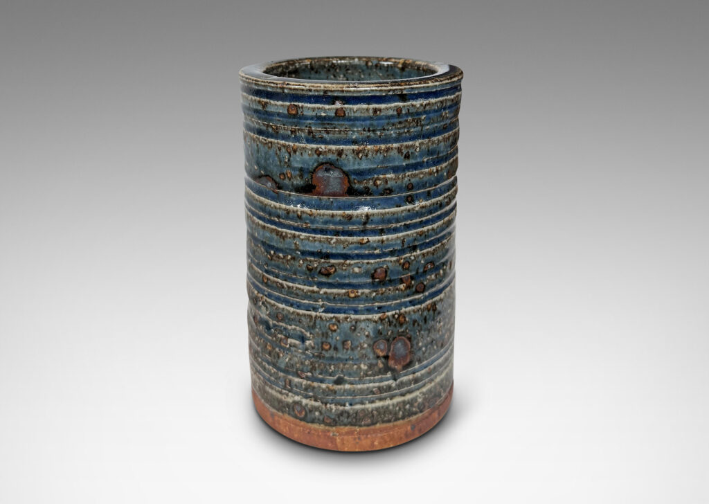 Gallery BAC cylindrical form with grog texture and carved ridging, glazed in a shiny cornflower blue with lustrous brown