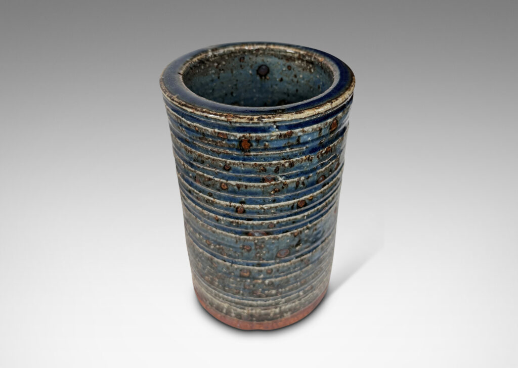 Gallery BAC cylindrical form with grog texture and carved ridging, glazed in a shiny cornflower blue with lustrous brown