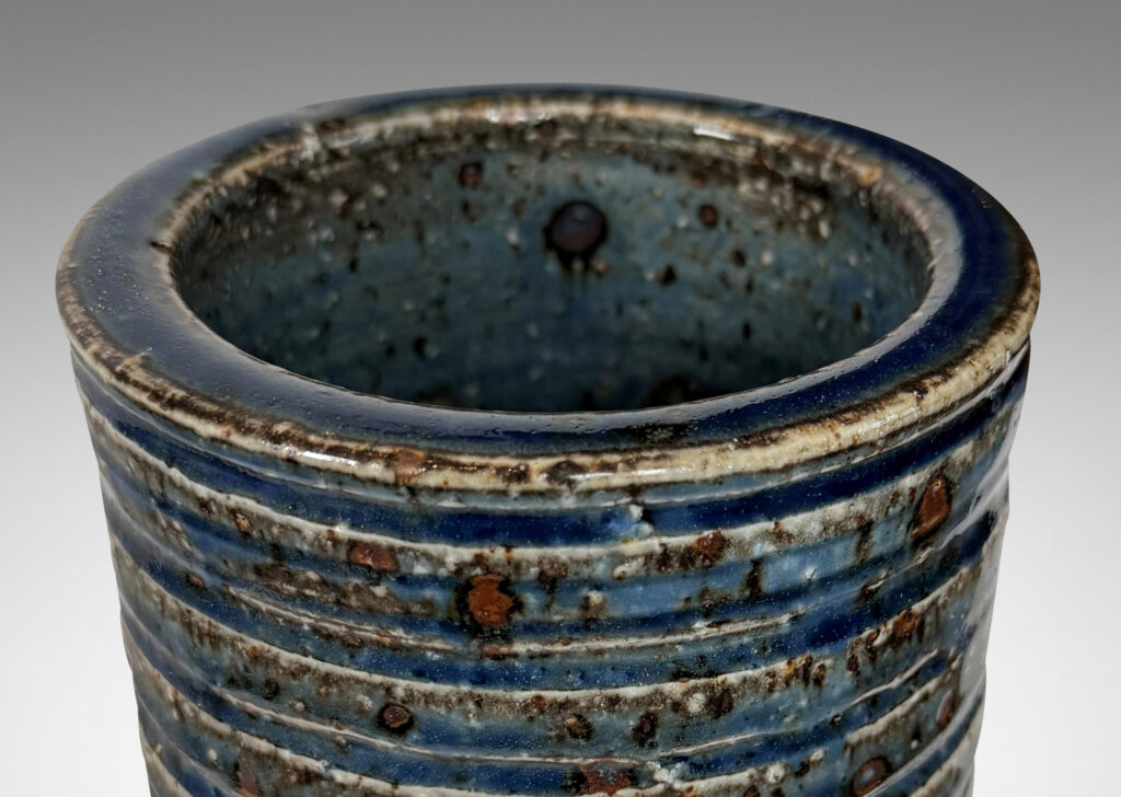Gallery BAC cylindrical form with grog texture and carved ridging, glazed in a shiny cornflower blue with lustrous brown